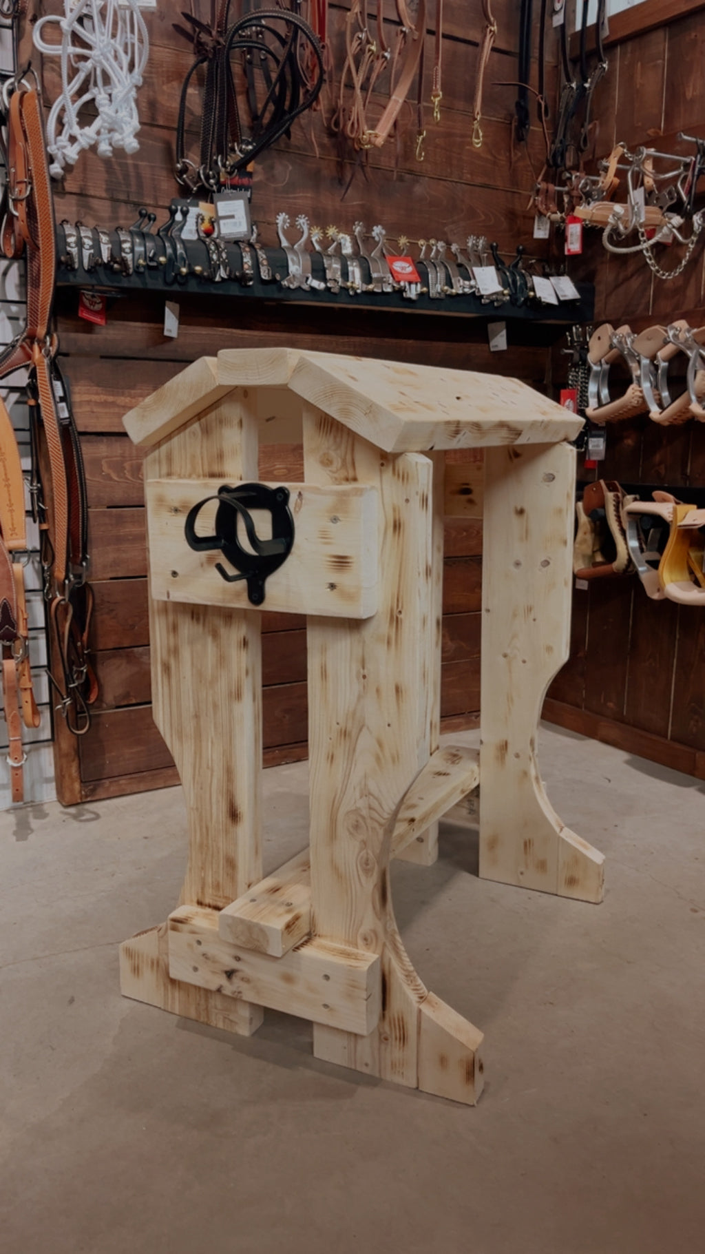 Support à selle en bois pour accessoires équestres, fabriqué par ES Sellerie Western, visible avec détails en bois naturel.